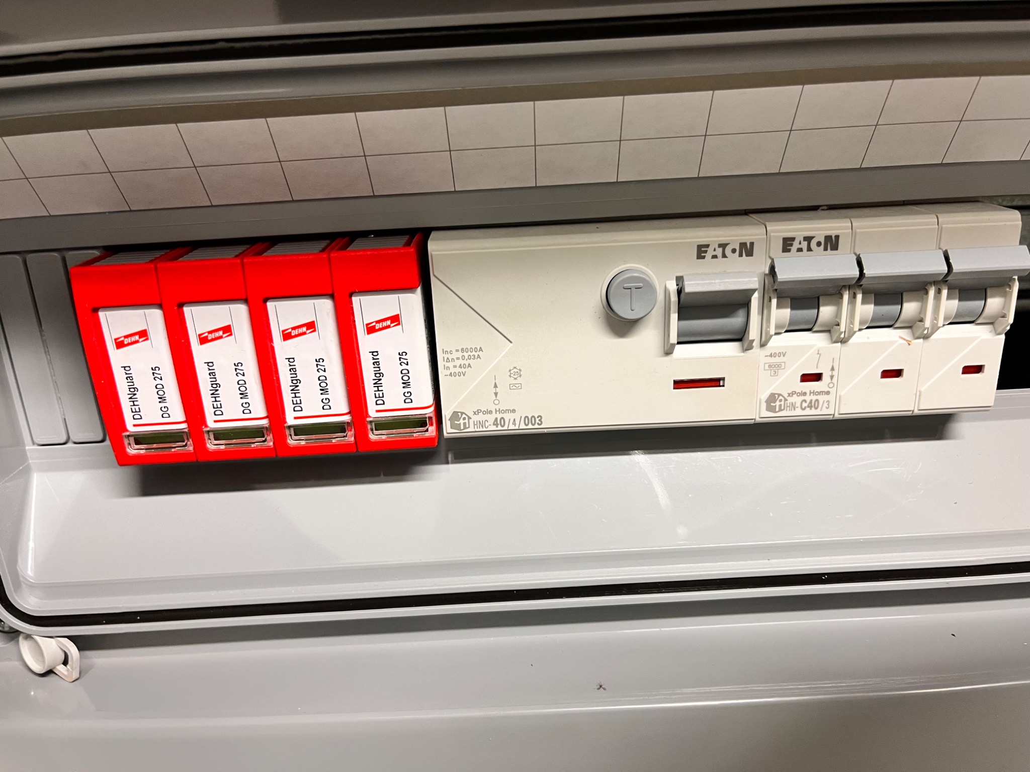 Rozdzielnica elektryczna z zamontowanymi ogranicznikami przepięć DehnGuard DG MOD 275 i wyłącznikami Eaton xPole Home, widoczne oznaczenia parametrów technicznych.