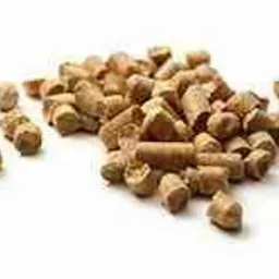 Niewielka sterta jasnobrązowego pelletu na białym tle, widoczne pojedyncze granulki o cylindrycznym kształcie i gładkiej powierzchni.
