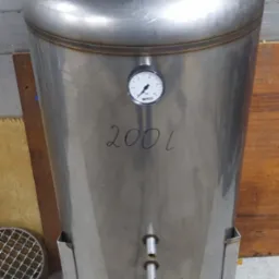 Stalowy zbiornik o pojemności 200 litrów z manometrem i trzema króćcami, spawany na stojaku, z napisem 'OK' na górze.