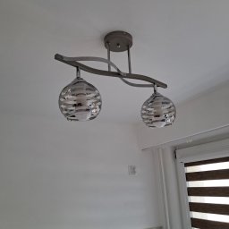 EL-ROB - Dwupunktowa lampa sufitowa z dekoracyjnymi, szklanymi kloszami w kształcie kuli, zamontowana na białym suficie w nowoczesnym wnętrzu. Widoczne okno z żaluzjami.