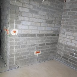 EL-ROB - Surowy mur z instalacją elektryczną: kable w peszlu, puszki podtynkowe. Etap prac przed tynkowaniem.