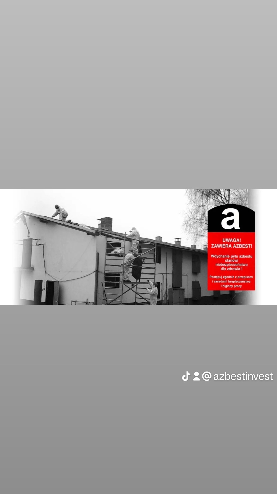 Pracownicy w kombinezonach ochronnych usuwają azbest z dachu budynku, na zdjęciu widoczny znak ostrzegawczy o zawartości azbestu.