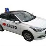 Biały samochód z niebieskim znakiem 'L' na dachu, oznaczony logo 'LAUTO' na boku, zaparkowany na białym tle.