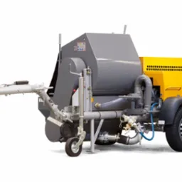 Mobilna pompa do betonu w kolorze szaro-żółtym na białym tle, widok z boku, z widocznymi elementami hydraulicznymi i złączkami.