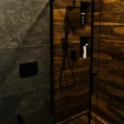 Nowoczesna łazienka z czarną armaturą: kabina prysznicowa z czarnymi ramami, deszczownica, toaleta w kolorze czarnym, ściany wyłożone płytkami imitującymi drewno i szarym kamieniem.