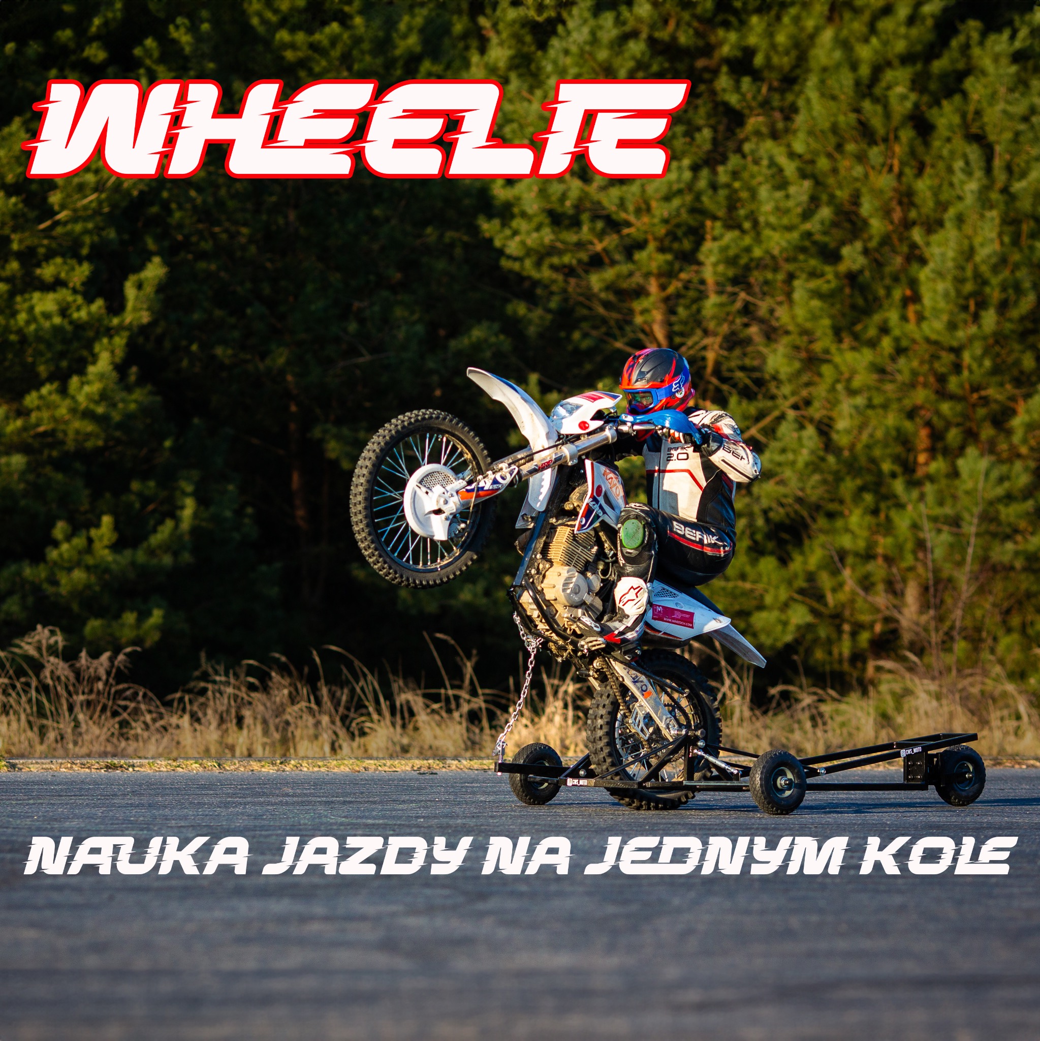 Instruktor na motocyklu enduro, wykonujący trik na jednym kole z użyciem specjalnego stabilizatora. W tle las i napis 'Nauka jazdy na jednym kole'.