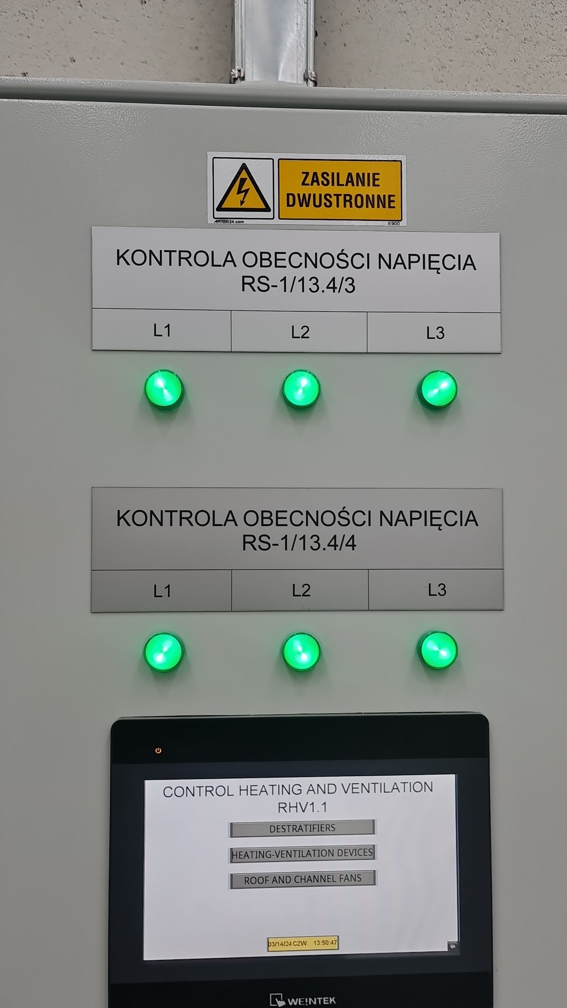 Panel sterowania z wyświetlaczem dotykowym i diodami LED sygnalizującymi obecność napięcia w trzech fazach (L1, L2, L3). Na panelu widoczne ostrzeżenie o zasilaniu dwustronnym.