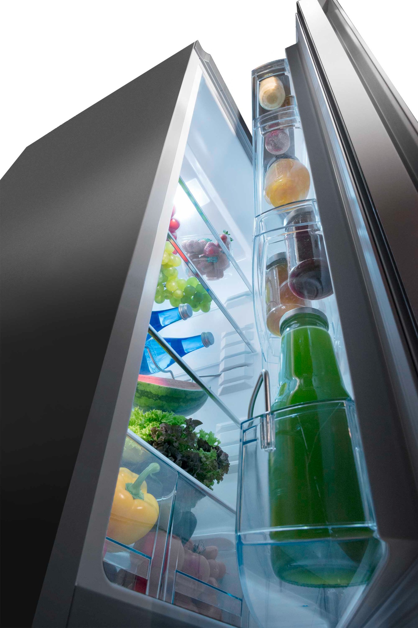 Wnętrze nowoczesnej lodówki z szarym wykończeniem, wypełnionej świeżymi owocami, warzywami, sokami i wodą mineralną, oświetlone wewnętrznym światłem LED.
