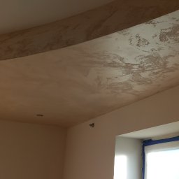 Mateusz Stanios - Ściana i sufit po nałożeniu gładzi, widoczna faktura i przygotowanie do malowania, okno zabezpieczone folią.
