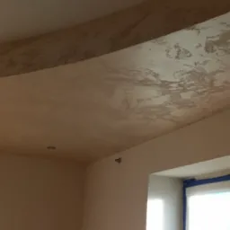 Ściana i sufit po nałożeniu gładzi, widoczna faktura i przygotowanie do malowania, okno zabezpieczone folią.