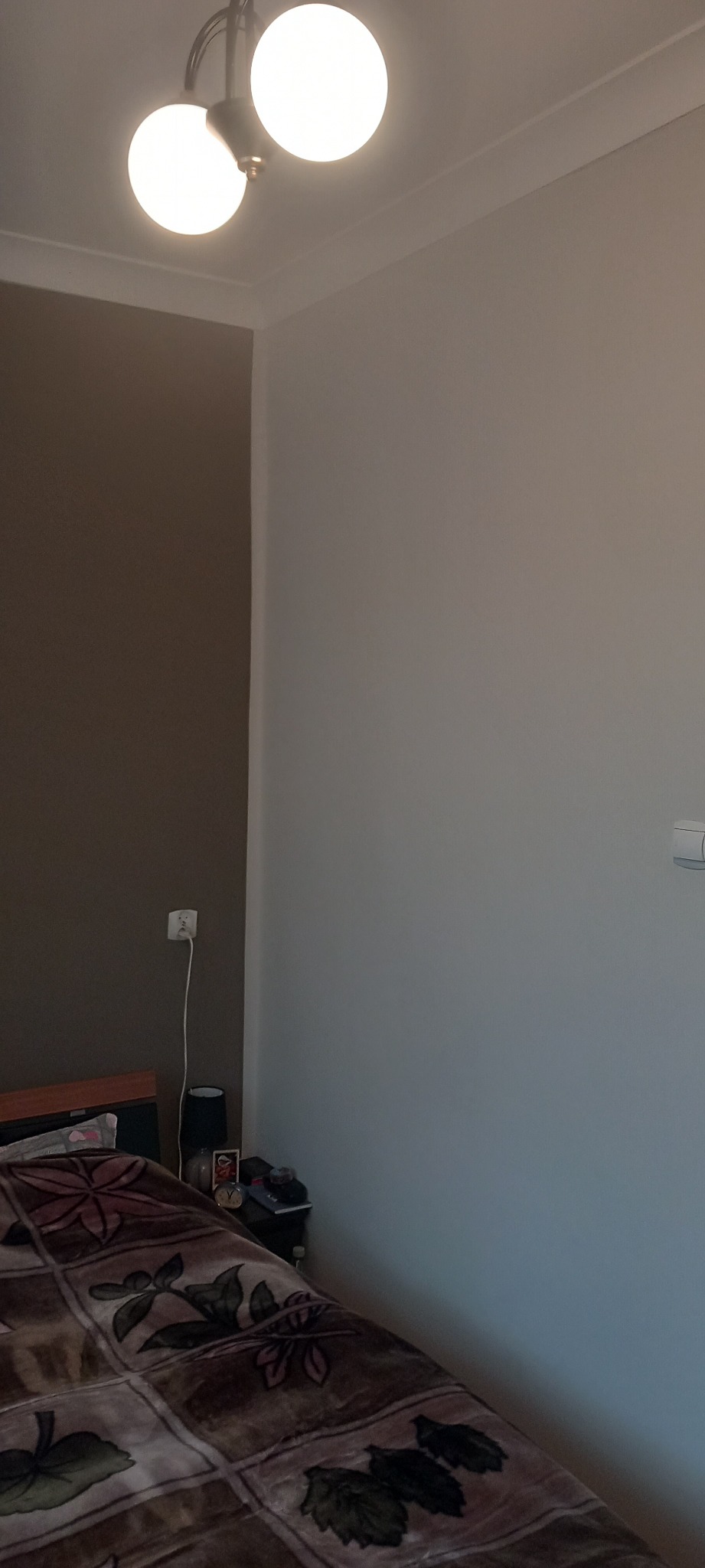 Pokój po malowaniu, widoczna ściana w dwóch odcieniach szarości, lampa sufitowa z dwoma kulistymi kloszami.