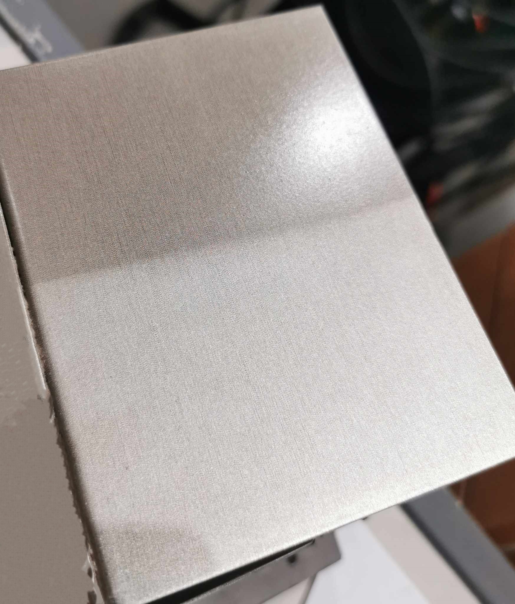 Szlifowana, metalowa powierzchnia po czyszczeniu, widoczne delikatne rysy i refleksy świetlne.