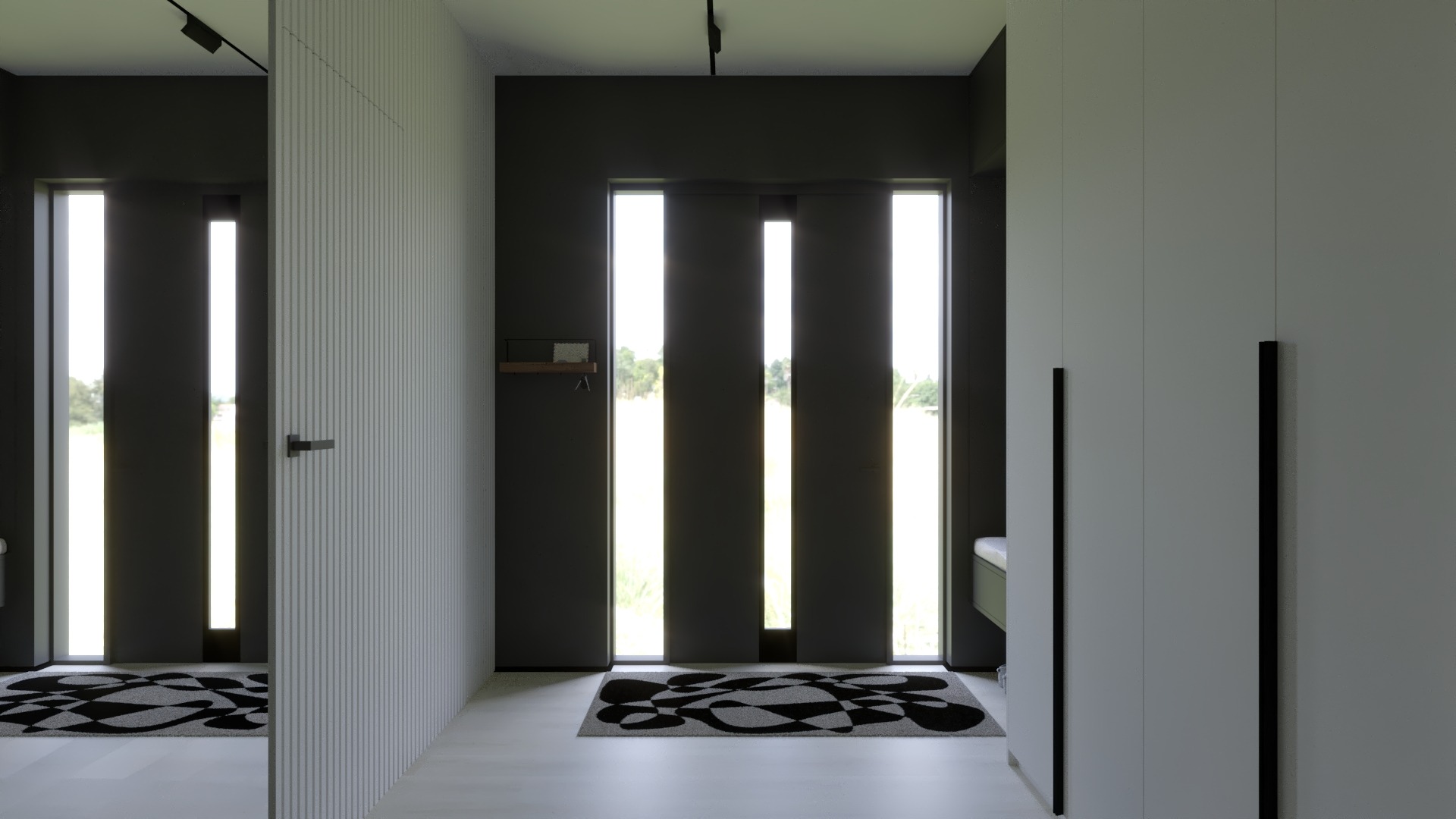 Nowoczesny przedpokój z szarą szafą w zabudowie, czarnymi uchwytami, minimalistycznym oświetleniem szynowym i geometrycznym dywanem przed drzwiami wejściowymi.
