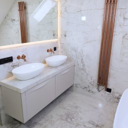 GRESLUX KRZYSZTOF PŁOCINIK - Elegancka łazienka w marmurze z dwoma umywalkami nablatowymi, miedzianą armaturą i grzejnikiem drabinkowym. Lustro z podświetleniem LED.