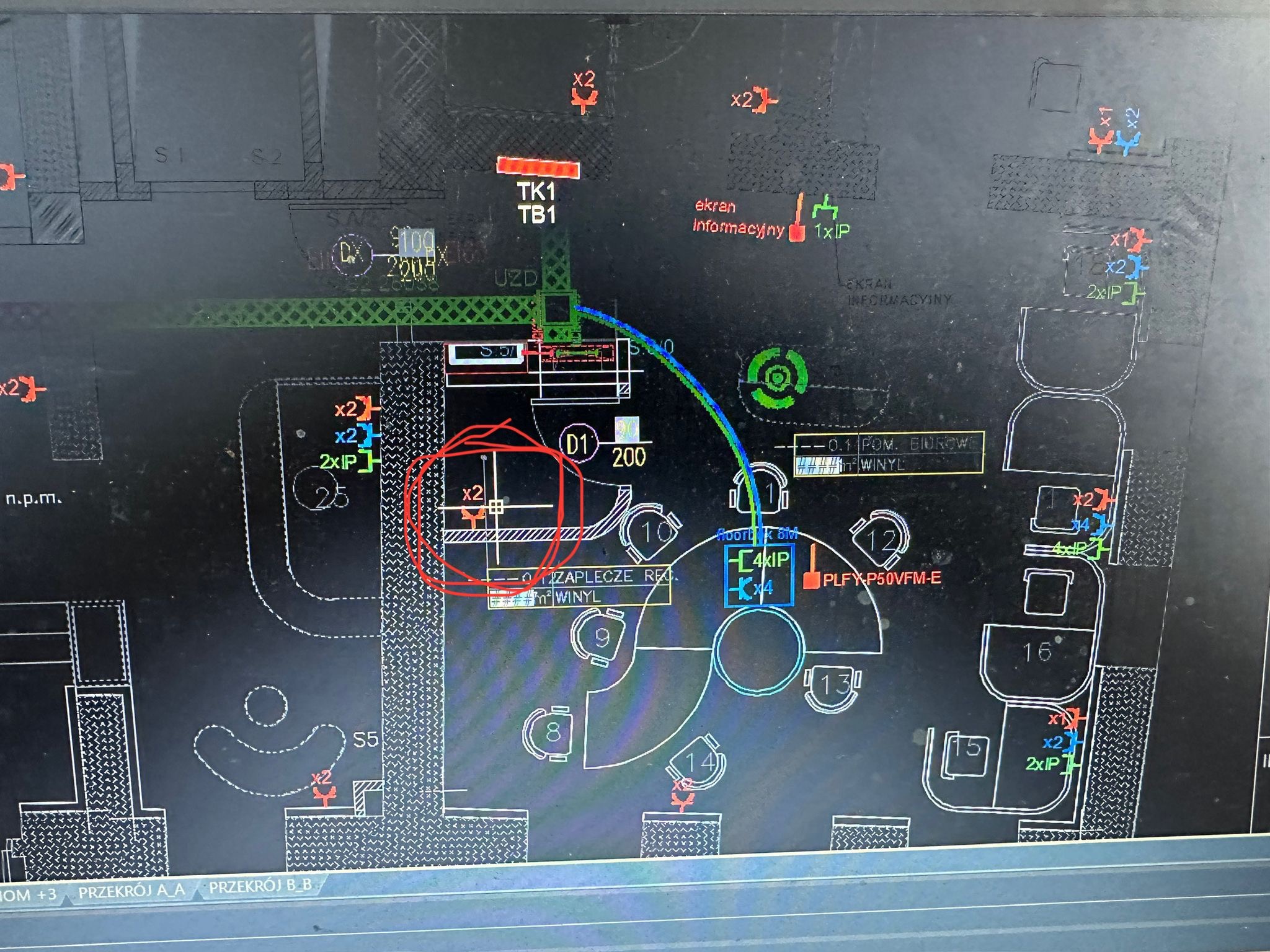 Rzut instalacji elektrycznej na planie budynku. Widoczne oznaczenia punktów elektrycznych, okablowania i innych elementów instalacji. Plan w kolorach białym, czerwonym, zielonym i niebieskim.