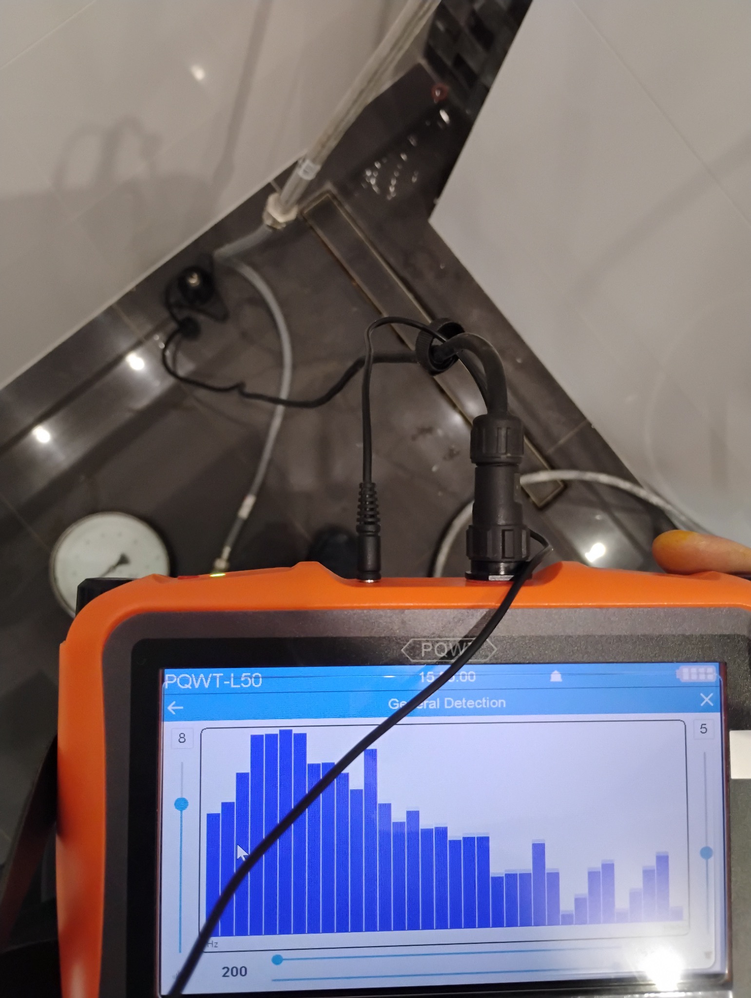 Pomiar ciśnienia w instalacji wodnej w Szamotułach za pomocą urządzenia PQWT-L50 z widocznym wykresem pomiarowym.