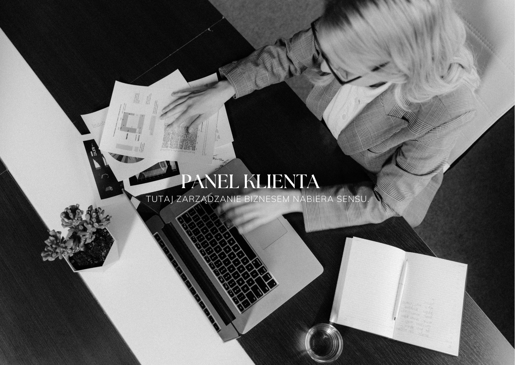 Czarno-białe zdjęcie z góry: kobieta w okularach analizuje dokumenty przy laptopie. Widoczne biurko, notatnik, roślina i szklanka. Panel Klienta - zarządzanie biznesem.