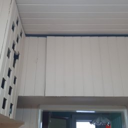 Mal&Mar - Białe panele boazeryjne na ścianach i suficie, widoczne nadproże drzwi, oświetlenie sufitowe.