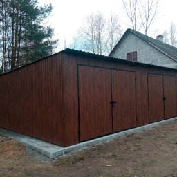 J.Chmielewski Conprometal Balustrady - Brązowy garaż blaszany z trzema bramami, stojący na betonowej wylewce, na tle drzew i murowanego budynku.