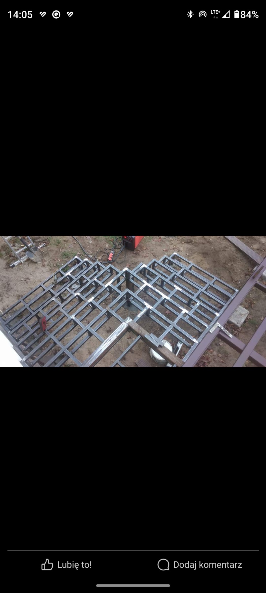 Metalowa konstrukcja szkieletowa w trakcie budowy, spawarka i narzędzia obok, widok z góry.