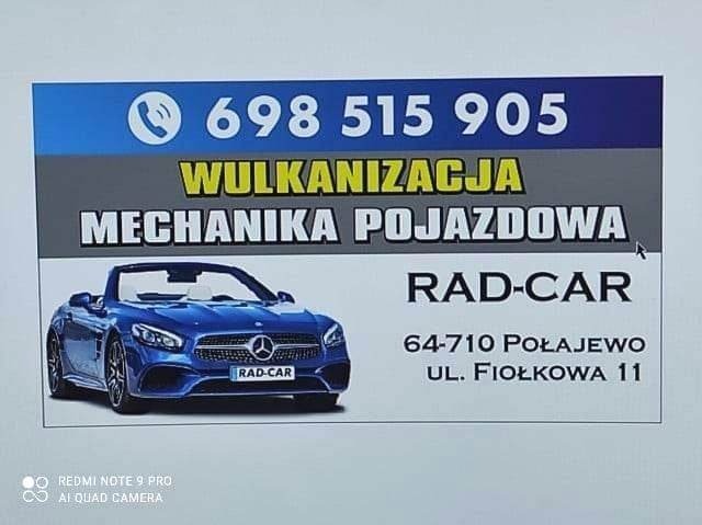 Szyld reklamowy warsztatu samochodowego z numerem telefonu, adresem i zdjęciem niebieskiego kabrioletu marki Mercedes.