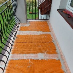 VELVET MIX DECORBUD Yurii Raba - Pomarańczowa mata drenażowa Schluter-DITRA ułożona na podłodze balkonu, przygotowana pod dalsze prace wykończeniowe.