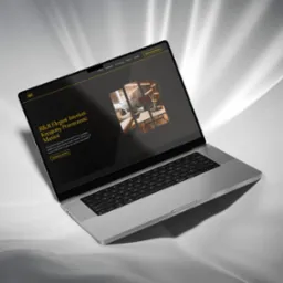 Laptop z wyświetloną stroną internetową firmy R&R Elegant Interiors, specjalizującej się w aranżacji wnętrz, na abstrakcyjnym, jasnoszarym tle.