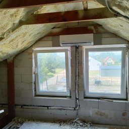 Clean&KlimaKing - Montaż klimatyzatora na poddaszu domu w trakcie wykańczania, widoczne okna, ocieplenie pianką, instalacja elektryczna.