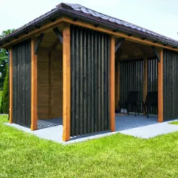 Nowoczesna, drewniana altana z ciemnymi, pionowymi panelami i brązowym dachem na tle zielonego trawnika i budynku. Widoczne krzesła wewnątrz.