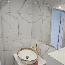 Alex Oleksandr Lisovyi - Umywalka nablatowa w stylu glamour z pozłacaną armaturą i marmurowymi płytkami w łazience po remoncie.