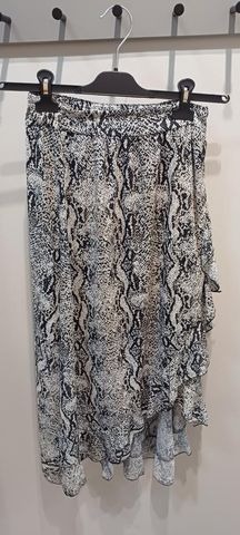 Asymetryczna spódnica damska w wężowy wzór, wisząca na wieszaku w sklepie w Suwałkach.