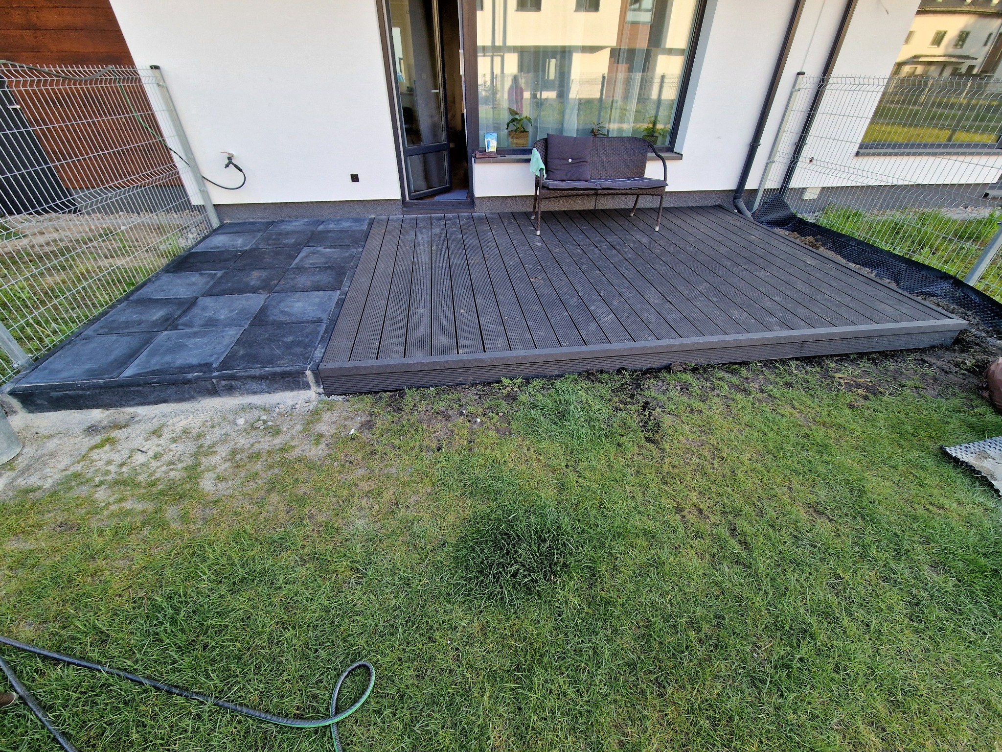 Taras z płyt betonowych, obok zlicowany taras z desek kompozytowych.