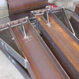 BEDSTALL Marlena Biedra - Metalowe elementy konstrukcyjne z widocznymi spawami i otworami, przygotowane do dalszego montażu. Widoczne oznaczenia 'P4' i 'REV' na jednym z elementów.