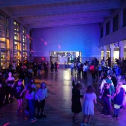 Daria Centka Jendrzej - Sala gimnastyczna oświetlona na niebiesko, wypełniona tańczącymi dziećmi podczas dyskoteki szkolnej. Widoczne efekty świetlne i dekoracje.