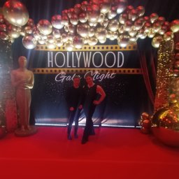 Daria Centka Jendrzej - Hollywood Gala Night: czerwony dywan, złote balony, dekoracje filmowe i dwie kobiety pozujące do zdjęcia. Event w stylu Hollywood.