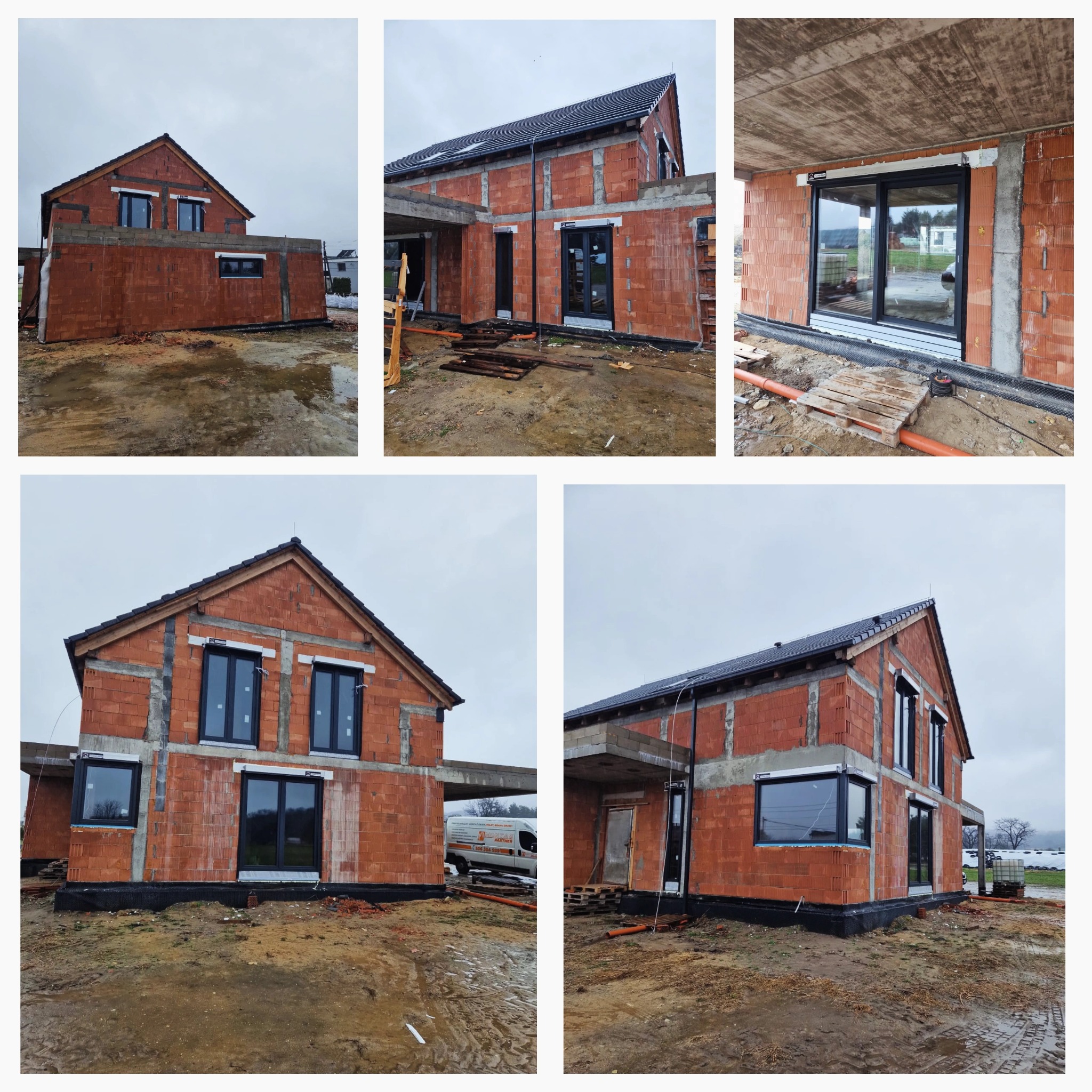 Surowy stan domu jednorodzinnego w trakcie montażu okien z czarnymi ramami; widoczne bloczki ceramiczne, betonowe nadproża, folia hydroizolacyjna przy fundamentach oraz błotniste podłoże.