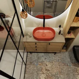 Wnętrze łazienki z kabiną prysznicową typu walk-in, umywalką w kolorze koralowym, szafką z drewnianymi frontami oraz toaletą w kolorze czarnym. Widoczne dekoracyjne oświetlenie i płytki podłogowe...