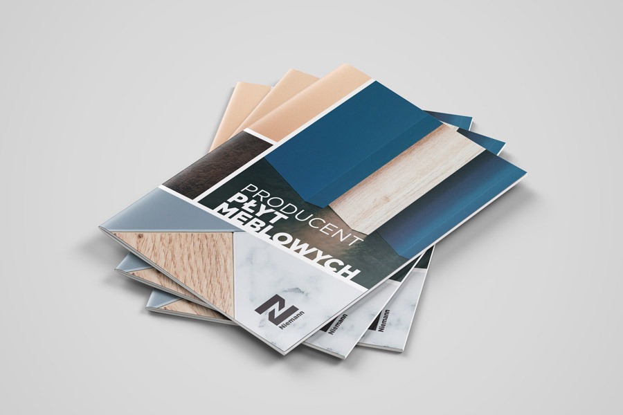 Stos ulotek reklamowych producenta płyt meblowych Niemann, z geometrycznym wzorem i próbkami materiałów na okładce, na jednolitym szarym tle.