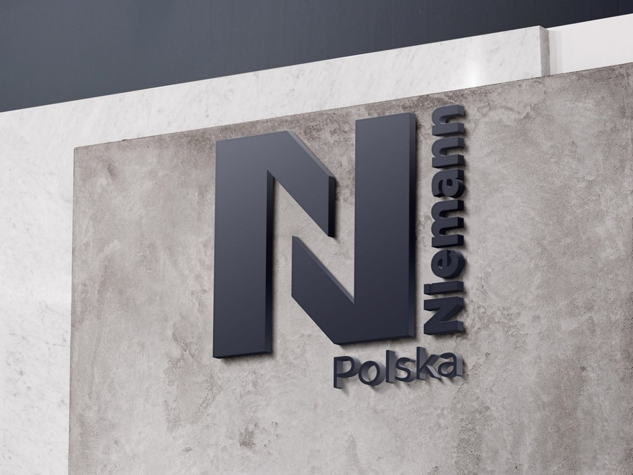 Eleganckie logo firmy Nieman Polska, wykonane z ciemnoszarego materiału, umieszczone na surowej, betonowej ścianie w minimalistycznym stylu.