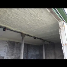 Poddasze ocieplone pianką PUR, widoczne elementy konstrukcyjne i instalacja elektryczna pod stropem.