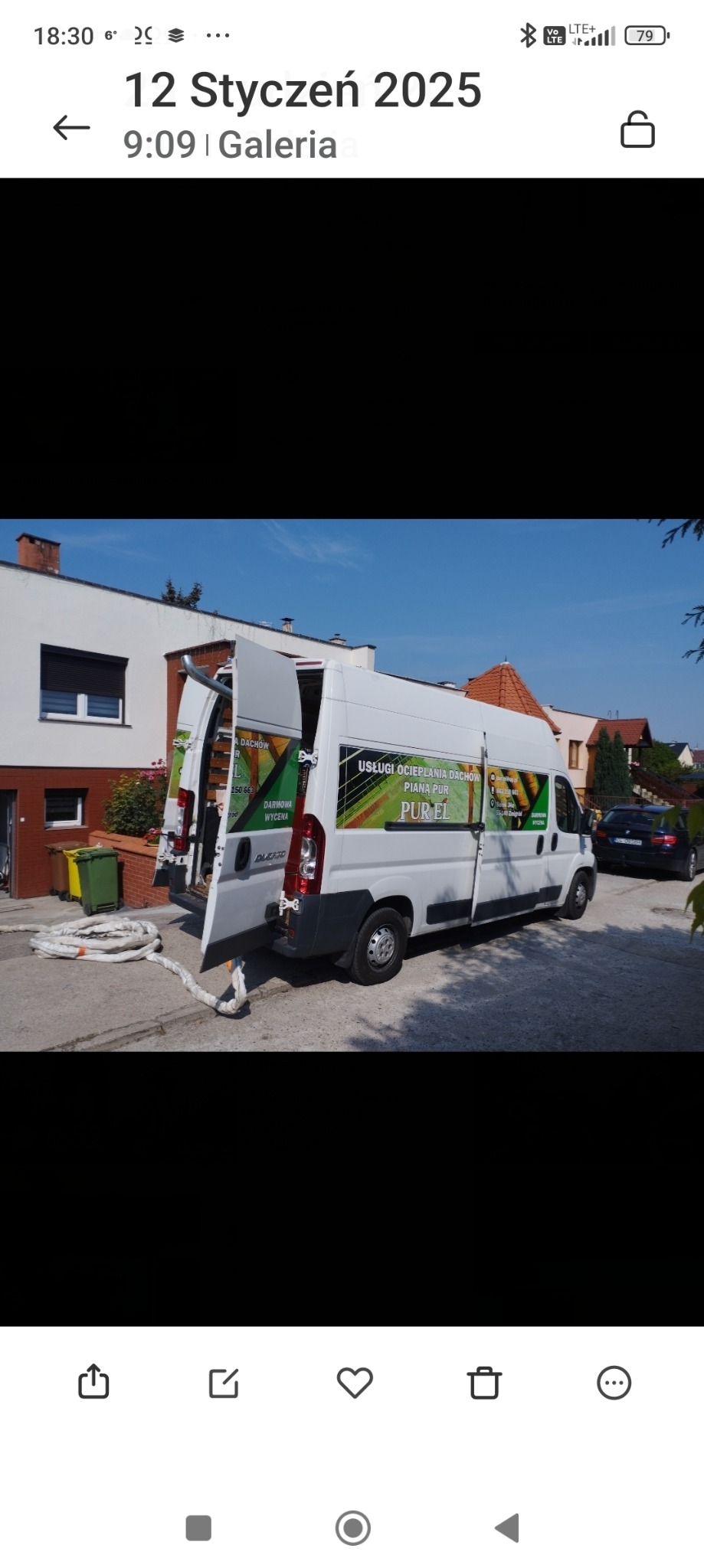 Biały samochód dostawczy z otwartymi drzwiami, oklejony reklamą usług ocieplania pianką PUR, zaparkowany na podjeździe przed domem jednorodzinnym, z widocznymi zwiniętymi wężami do aplikacji izolacji.