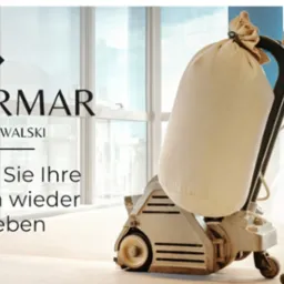 Pracownik w ubraniu roboczym cyklinuje drewnianą podłogę za pomocą profesjonalnej maszyny do cyklinowania z workiem na pył na tle jasnego pomieszczenia z dużymi oknami, widoczne logo firmy...