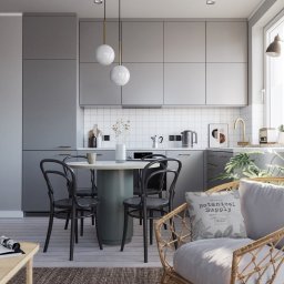 PURSSU STUDIO EWA KUROWSKA - Nowoczesna kuchnia w szarościach z okrągłym stołem i krzesłami w stylu retro. Minimalistyczne oświetlenie i dekoracje roślinne dodają przytulności. W tle biała mozaika.