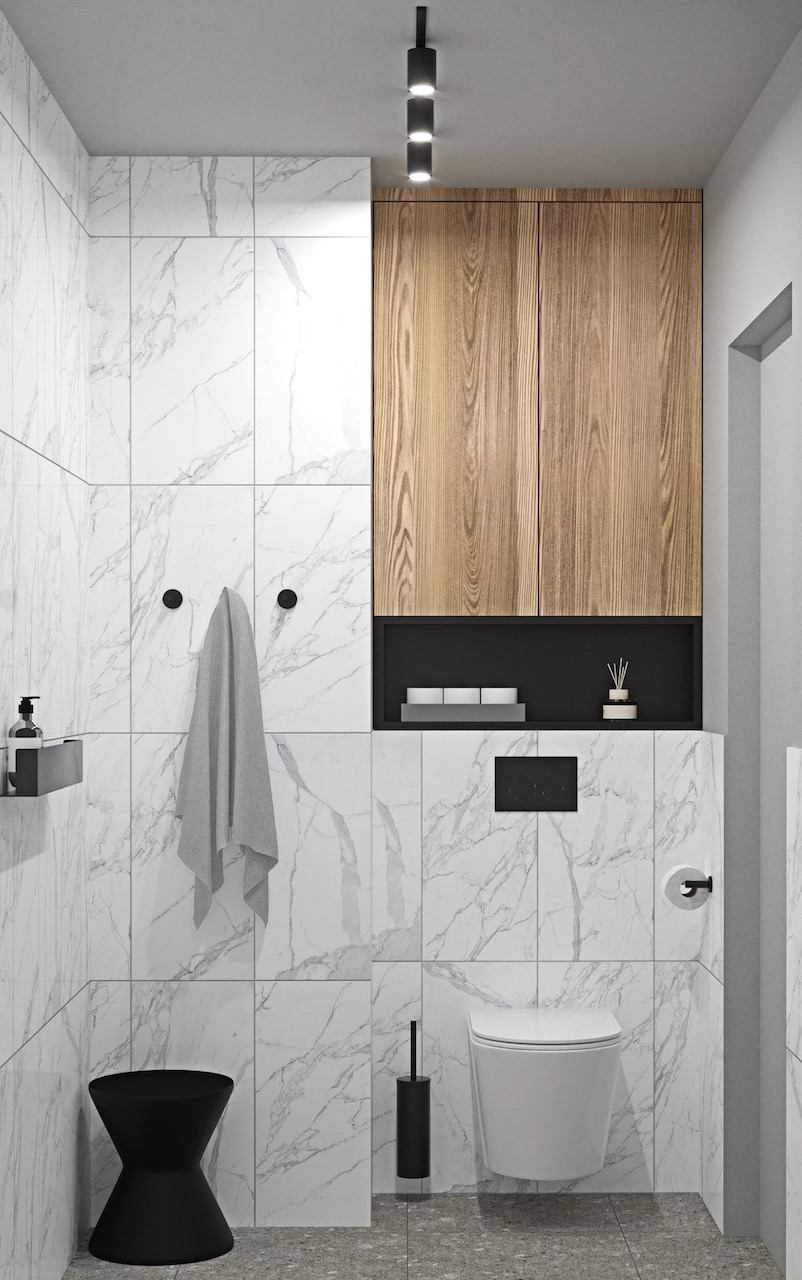 Nowoczesna łazienka z marmurowymi płytkami, drewnianymi szafkami i czarnymi akcentami. Minimalistyczny design z sedesem podwieszanym i subtelnym oświetleniem.