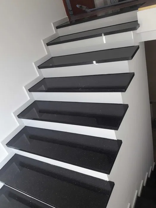 Schody z czarnego granitu z białymi podstopnicami, widok z dołu, połyskujące powierzchnie, nowoczesny design.