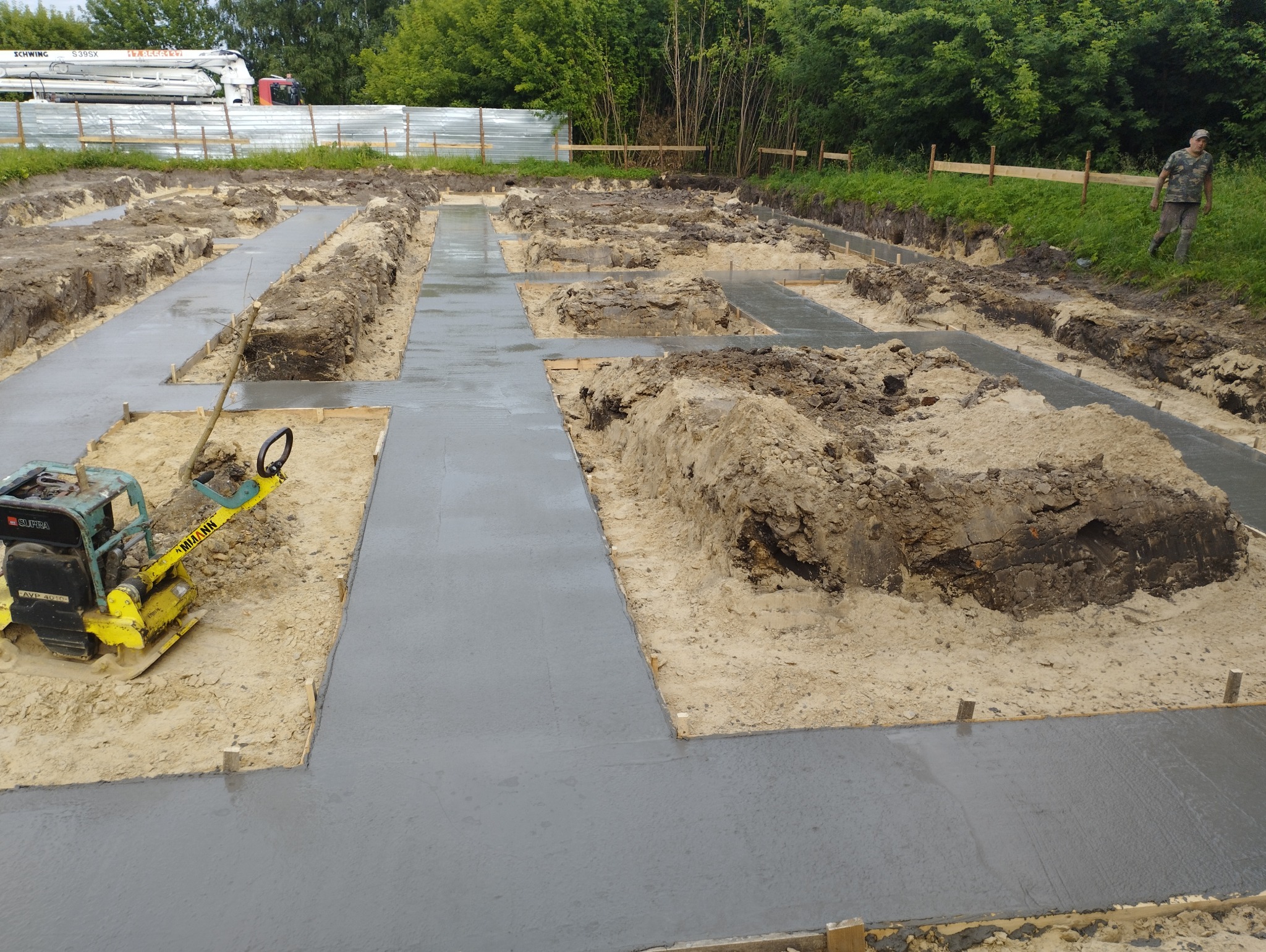 Wylane fundamenty pod dom w Radomyślu nad Sanem, widoczny ubijak wibracyjny i wykopane rowy.