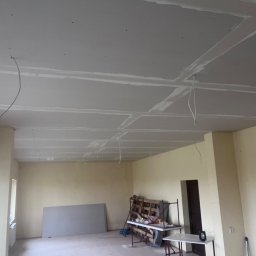 Wykończenia wnętrz - Wnętrze w Kielcach z widocznym sufitem z płyt kartonowo-gipsowych, przygotowanym do szpachlowania i malowania, z wystającymi przewodami elektrycznymi.