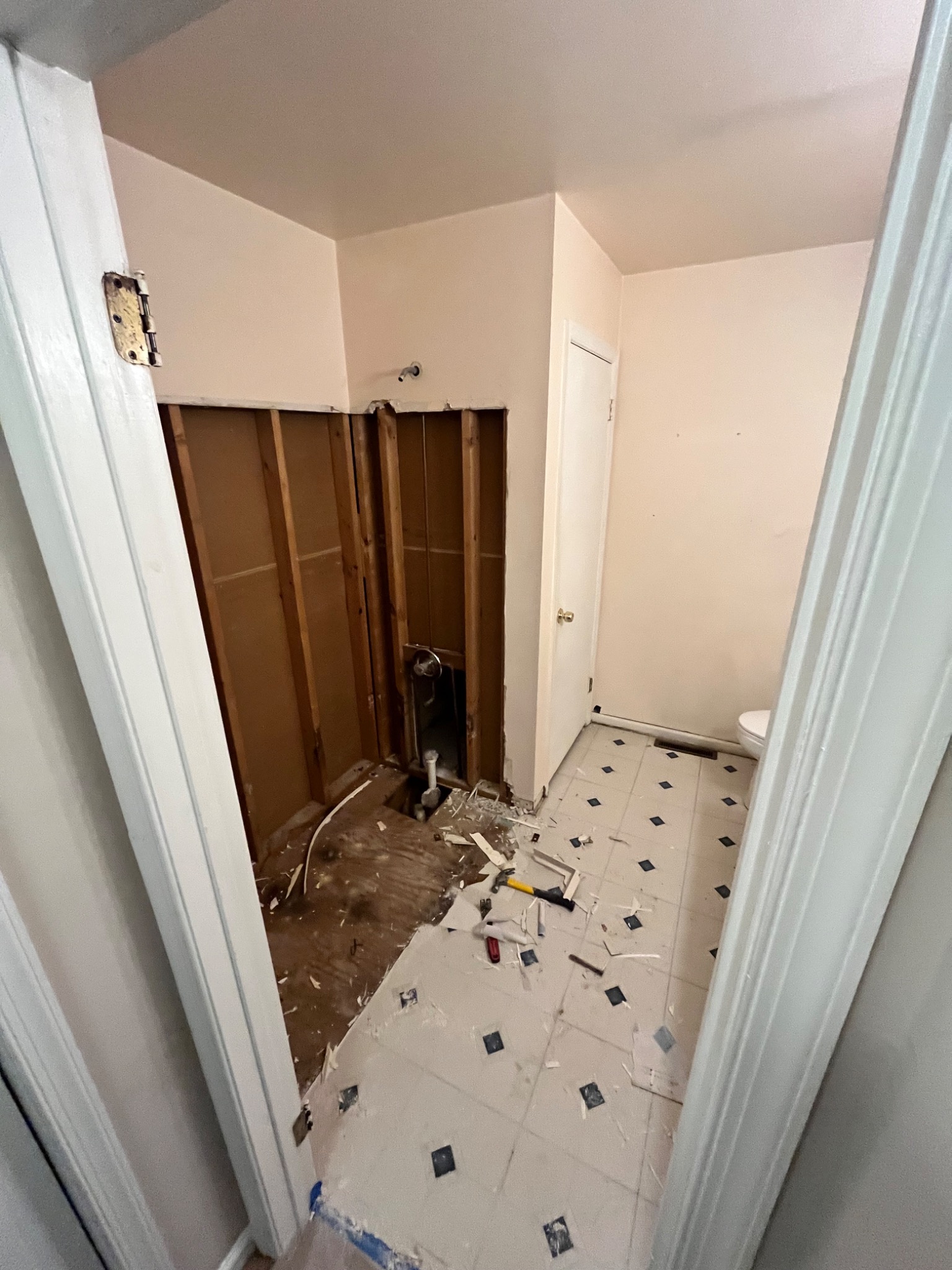 Demontaż starej instalacji w trakcie remontu łazienki w Kielcach, widoczne odsłonięte rury, usunięte płytki i narzędzia na podłodze.