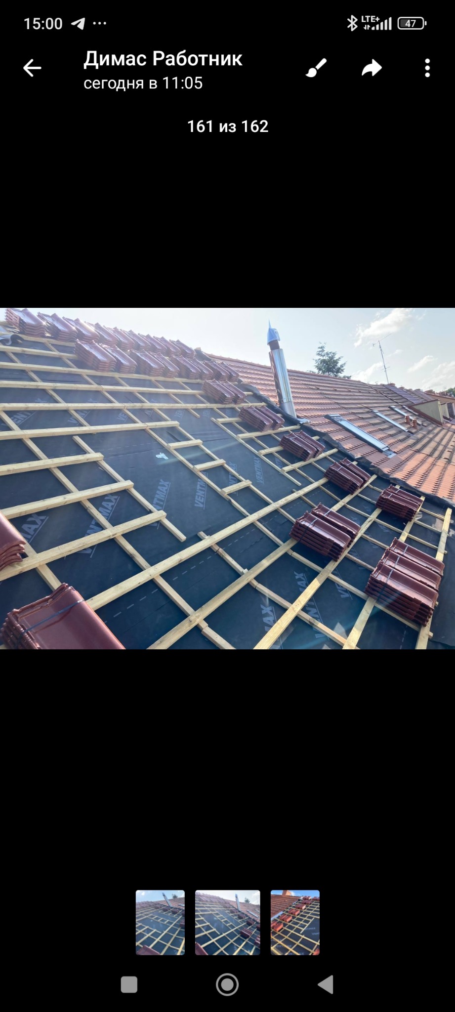 Częściowo pokryty dach z brązową dachówką, widoczna konstrukcja drewniana i membrana. Fragment komina. Dach w trakcie prac dekarskich.