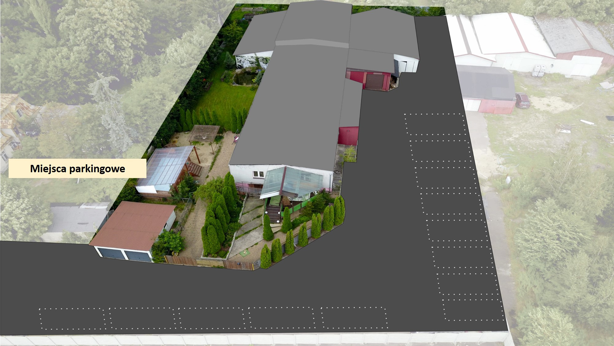 Widok z lotu ptaka na budynek z miejscami parkingowymi, otoczony zielenią i drzewami.
